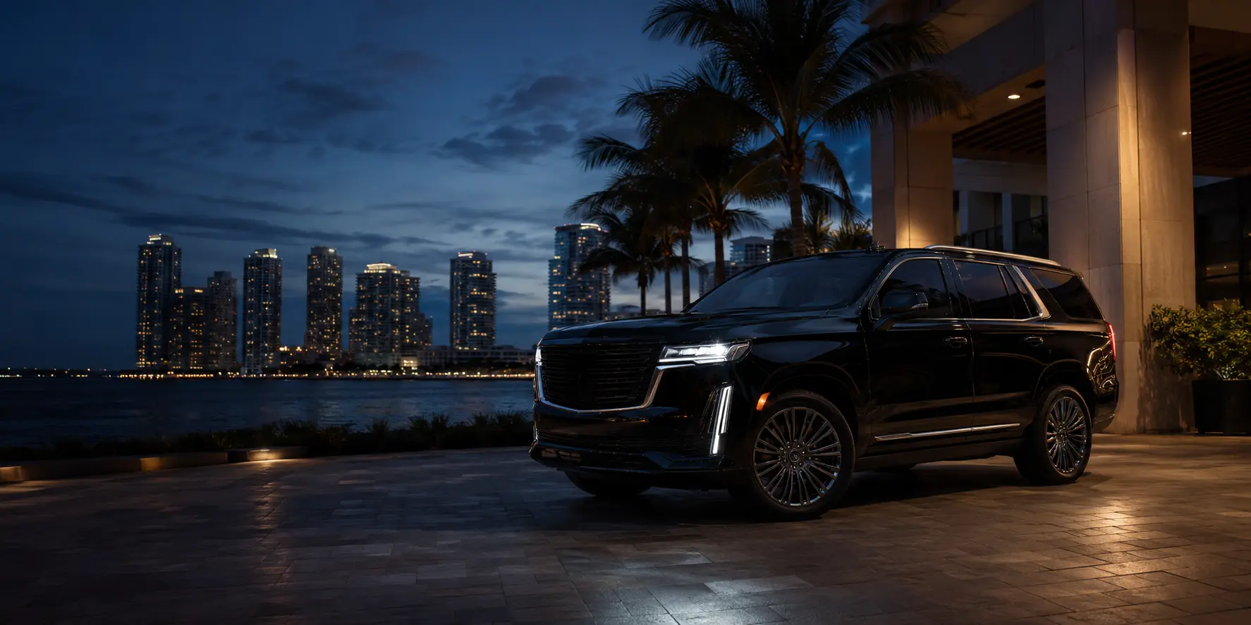 Black luxury SUV outside a Miami waterfront hotel at night